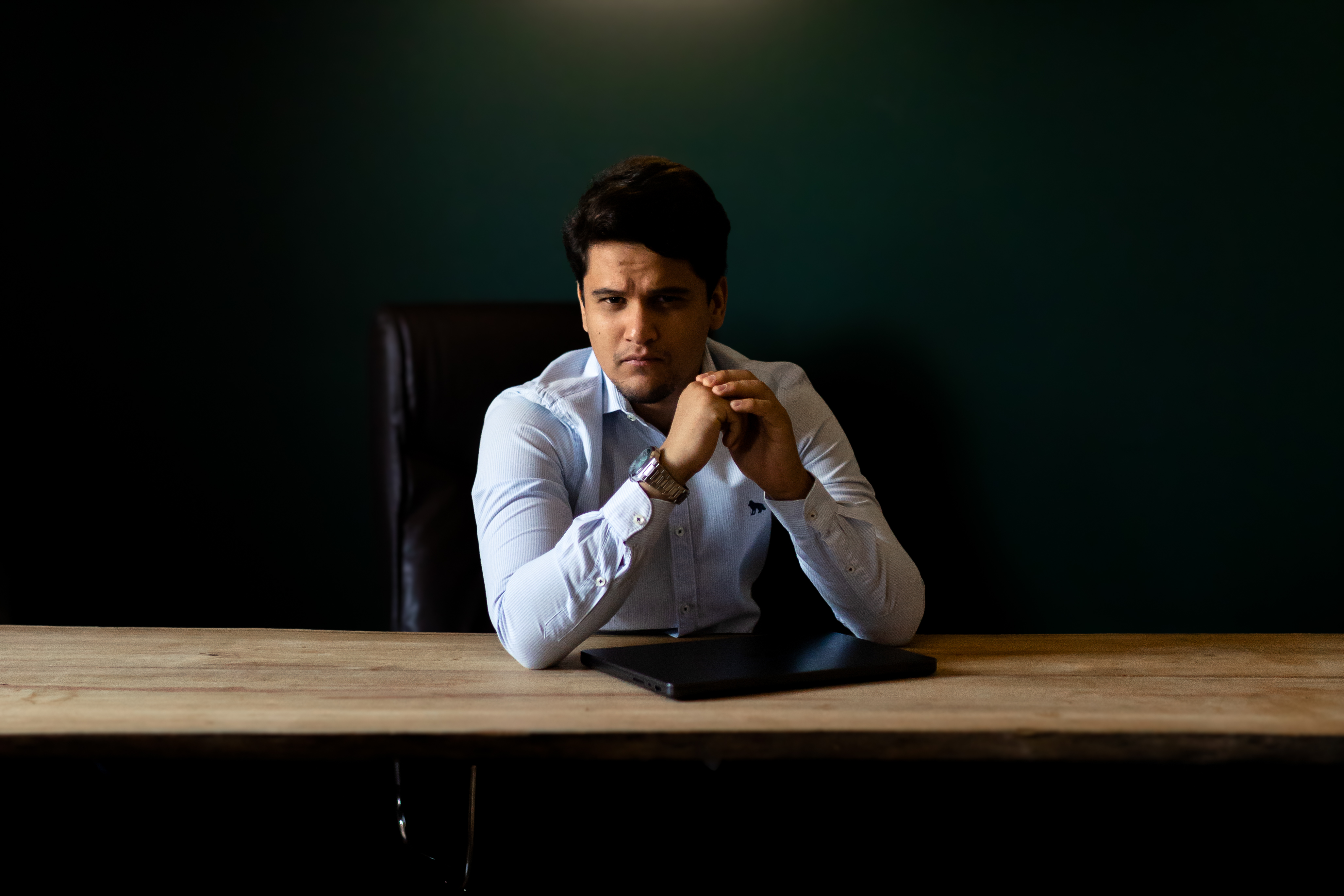 Lucas Paula sentado à mesa em seu ambiente de trabalho